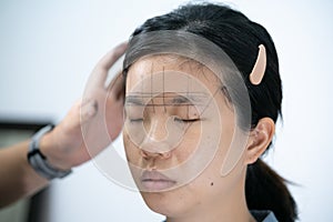 The process of shaping eyebrows by a beauty master with a thread for a young asian lady - Eyebrows microblading concept