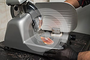 The process of slicing ham on a slicer.