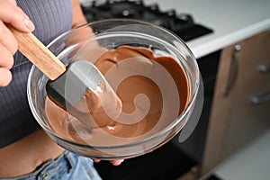 The process of tempering chocolate and making chocolates. Pastry chef using spatula tempering molten chocolate