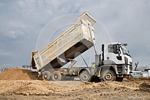 Process of transporting and unloading soil on a construction machine