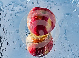 Washing one red apple with reflection and with splashes and drops of water photo