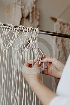 The process of weaving macrame. Hands weave macrame decor