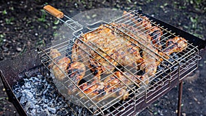 Processcooking chicken legs and chicken breast on a barbecue grill outdoors. Picnic, eating outdoors. Metal barbecue