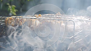 Processcooking chicken legs and chicken breast on a barbecue grill outdoors. Picnic, eating outdoors. Metal barbecue