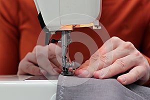 Processes of sewing flax on the sewing machine sew women`s hands sewing machine Linum. sewing machine and female fingers out of