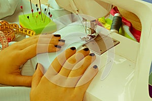 Processes of sewing on the sewing machine sew women`s hands sewi