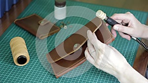 Processing and manufacturing of leather goods with a power tool close-up on a blurred background of a workshop