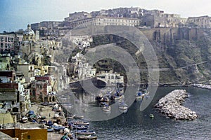 PROCIDA, ITALY, 1975 - The old Procida prison dominates the Marina di Corricella with its fishing boats