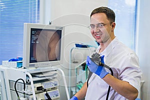Proctologist doctor holding Ligador hemorroidal in office photo