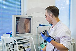 Proctologist holding an anoscope against a proctological chair. In the hospital