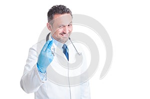 Proctologist showing two fingers with surgical latex gloves photo