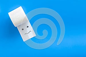 Proctology concept with toilet paper roll and painted face on blue background top view mock up