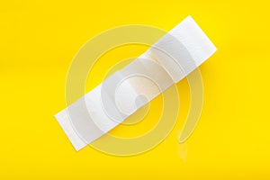 Proctology concept with toilet paper on yellow background top view