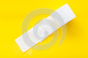 Proctology concept with toilet paper on yellow background top view