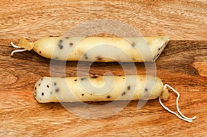 Produce of Spain - stick of hard goat cheese with whole plack peppercorns