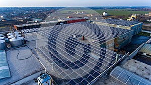 Producing green electicity sunlight energy. Solar panel cells on the industrial roof.