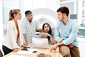 Producing new and creative ideas as a team. a group of businesspeople having a discussion in an office.