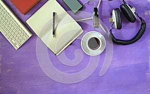 Producing podcast with stylish headphones,vintage microphone,coffee,smartphone,computer keyboard on purple  table.Flat lay with