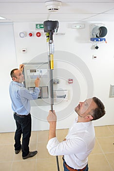 Product inspectors testing smoke detector