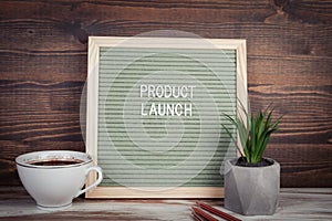 Product Launch. English text on a letter Board. Stationery on a wooden table