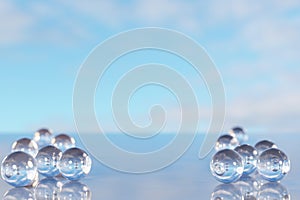 Product placement and advertising background. Glass balls on empty marble surface against blue sky with clouds. Backdrop for