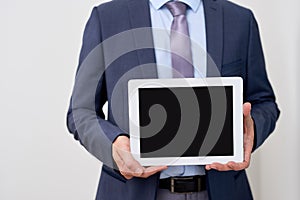 Product presentation. Promotion. Business man holding in hands tablet computer with blank screen, close up