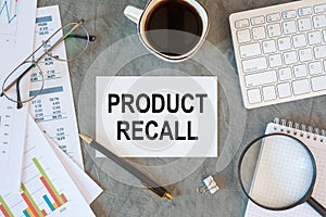 PRODUCT RECALL is written in a document on the office desk, keyboard and diagram