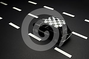 Product shot of a Classic Black Toy Model Car on a black background and road lanes