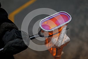 Production of aluminum. Melting furnace on a black background. Aluminum foundry. Orange bright molten steel.