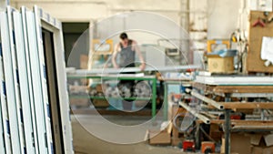 The production of assembly and manufacturing of PVC windows, a workshop with finished products, in the background, a