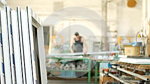 The production of assembly and manufacturing of PVC windows, a workshop with finished products, in the background, a