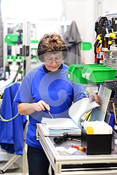 production and assembly of microelectronics in a hi-tech factory - older woman assembles components photo