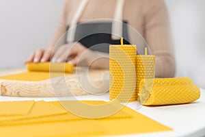 Production of candles from yellow beeswax with smell of honey, woman in apron