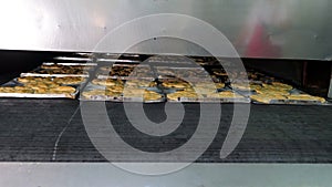 Production of confectionery products. Cakes on an automatic conveyor belt, the process of baking cakes at the factory