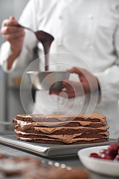 The work of a confectioner, making a cake. pastry chef in white uniform while working in a pastry shop. restaurant