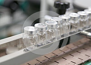 Production line with glass ampoules and medicine at the factory. Pharmaceutical industry