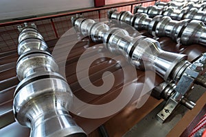 Production line of metal tile for roof. Steel forming machine in metalwork factory workshop. Metal sheet profiling photo