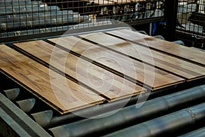 Production line of the wooden floor factory. CNC automatic woodworking machine.