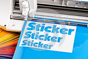 Production making sticker with plotter cutting machine cyan blue colored vinyl fim with color fan. guide. Advertising Industry diy