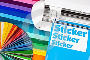 Production making sticker with plotter cutting machine sheets of colorful various rainbow colored vinyl fim with color fan. guide photo