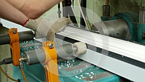 Production and manufacturing of pvc windows, a female worker installs a pvc profile in the machine and drills a hole