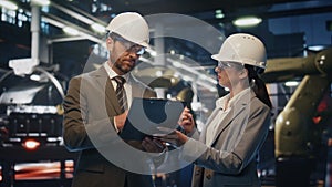 Production owners inspect factory premises in protective helmets close up.