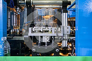 The production of PET bottles in the automatic blowing machine for drinking water factory.