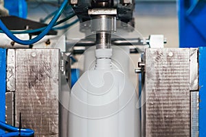 Production of plastic canisters on an automatic conveyor.
