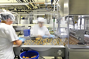 Production of pralines in a factory for the food industry - women working on the assembly line