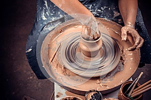 production process of pottery. Forming a clay teapot on a potter& x27;s wheel.