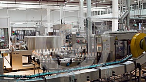 The production room of the dairy plant. Milk bottles are moving on a conveyor belt. The general plan.