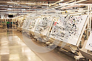 Production room with stands for manufacturing electric wiring for cars at a modern plant