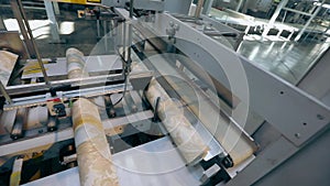 Production of wallpaper, a roll of wallpaper on a conveyor line, the final process for the production of wallpaper