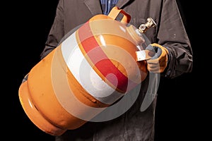 A production worker with a gas cylinder. Man carrying dangerous explosives